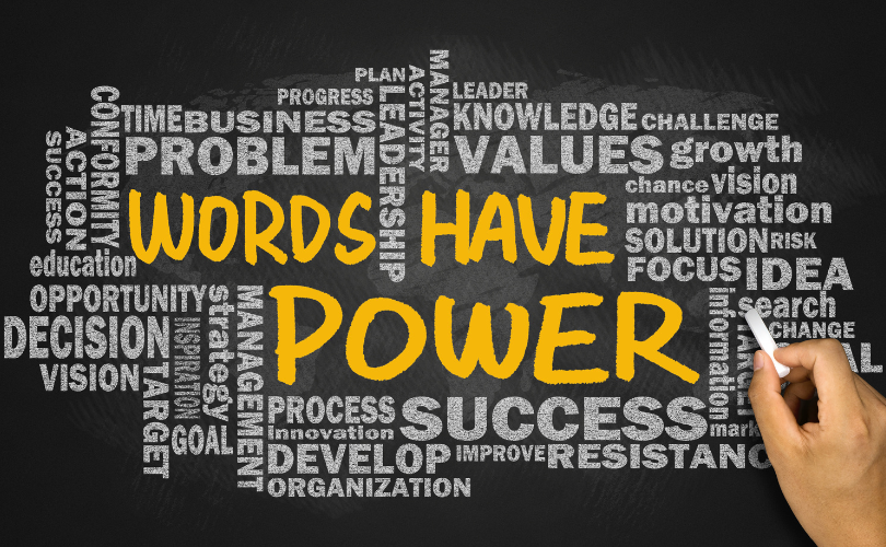 Black background with a collection of words in grey. In the center of the words, in large test and gold color appears “Words Have Power”